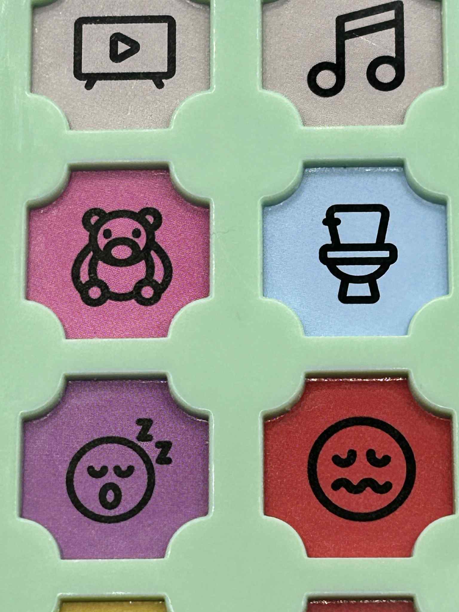 Close-up of ASD Communication Device showing colourful communication buttons and icons for visual learning