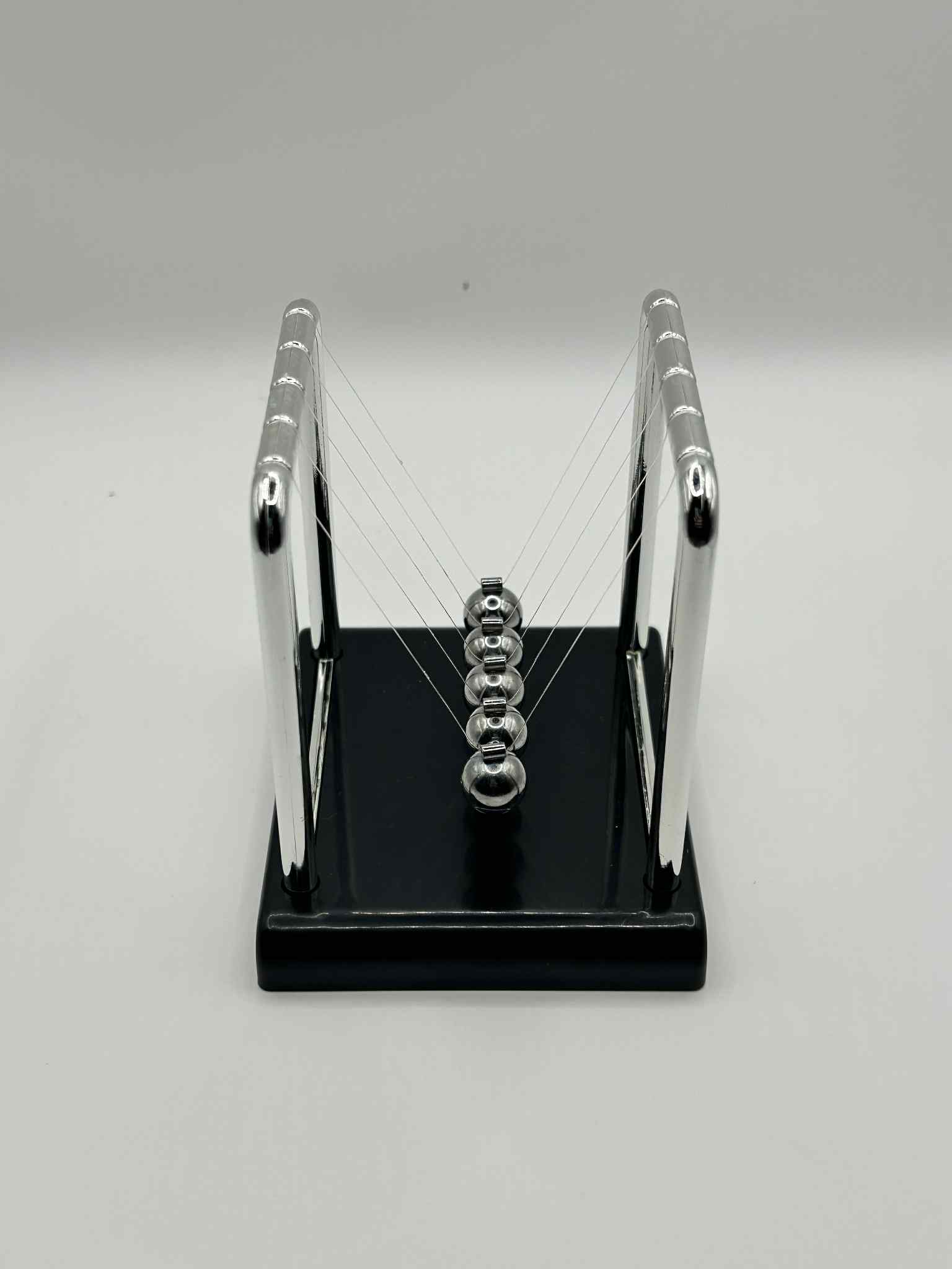 Metal Newton’s Cradle on black base – desktop fidget and stress-relief toy for neurodivergent children | The Divergent Den