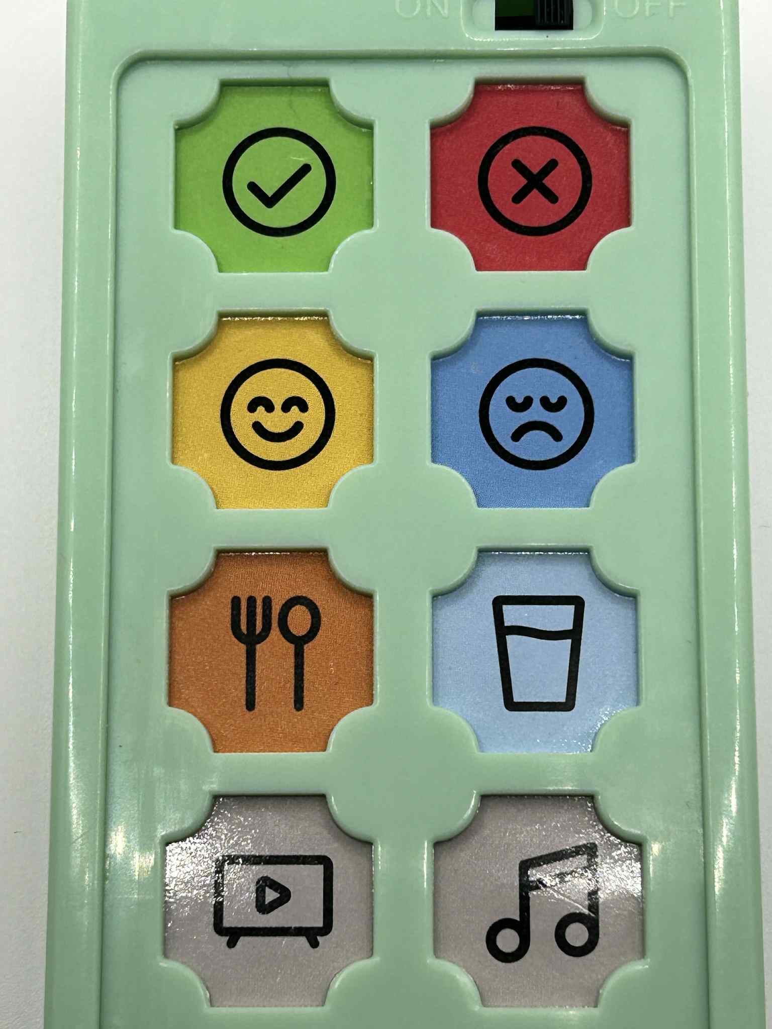 Close-up of ASD Communication Device showing colourful communication buttons and icons for visual learning