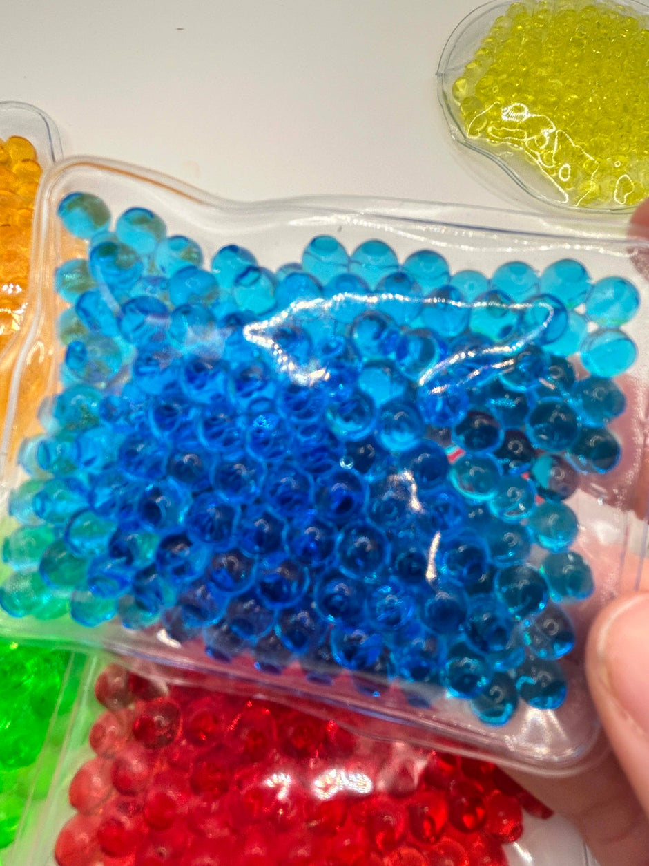 Six different water bead sensory shapes in vibrant colours for neurodivergent children