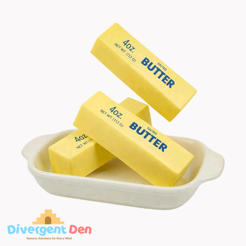 Three blocks of butter fidget in a white dish with 'Divergent Den' branding.