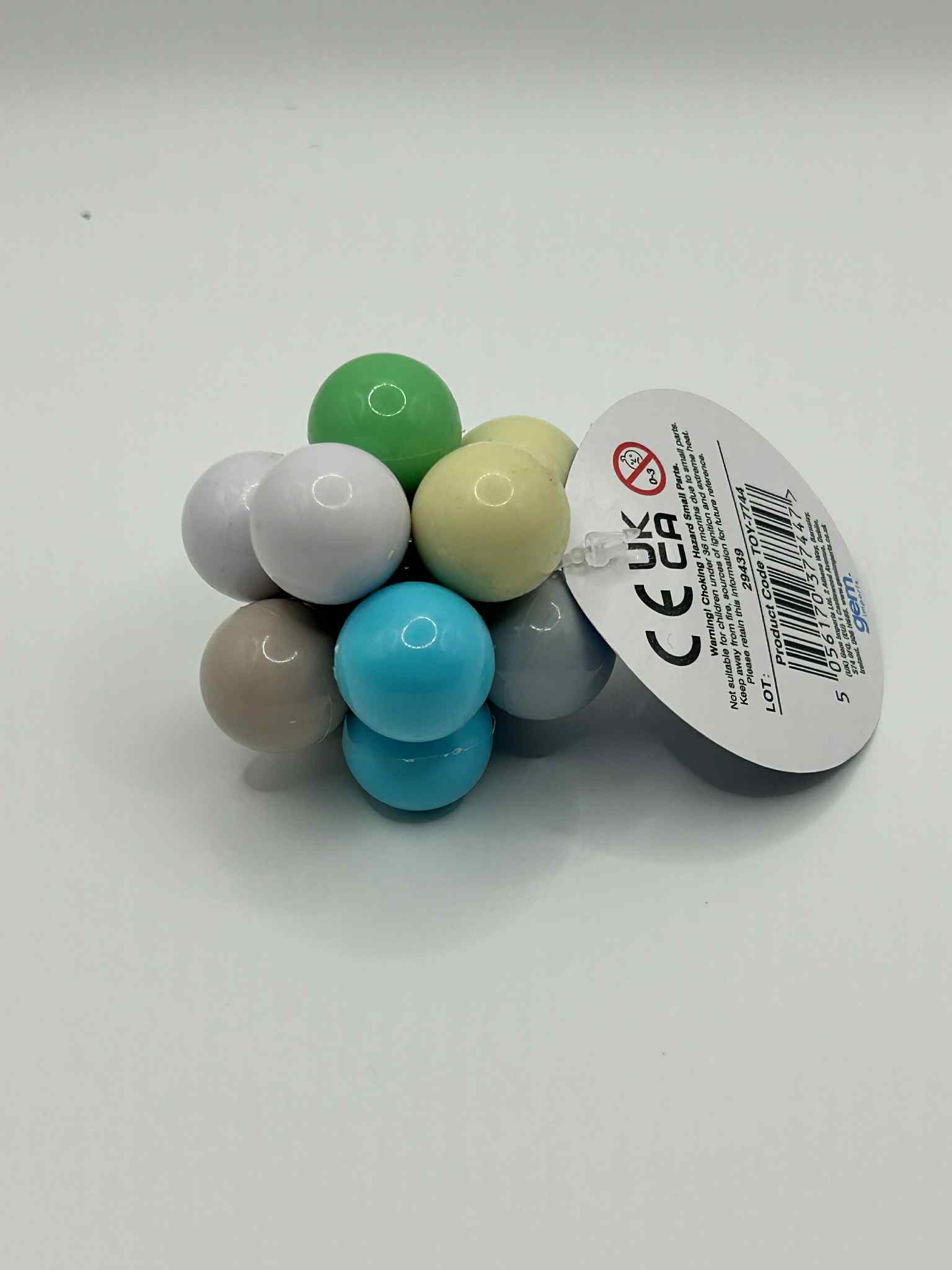 Fidget Atom close-up of label showing UCKA Number showing multi-coloured tactile buttons for stress relief and focus