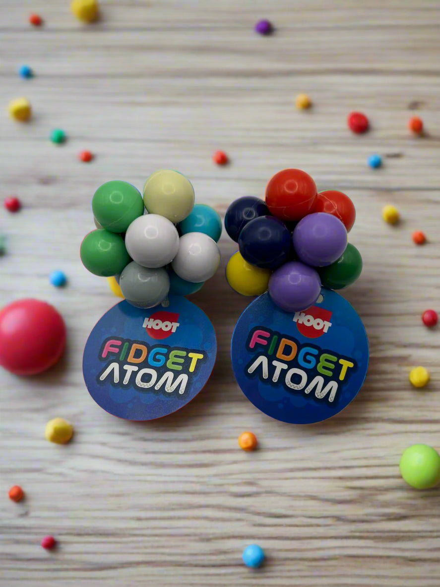 Fidget Atom product page showing a nice background with two fidget atoms on a table showing multi-coloured tactile buttons for stress relief and focus