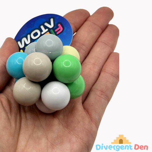 Fidget Atom close-up in a hand showing multi-coloured tactile buttons for stress relief and focus