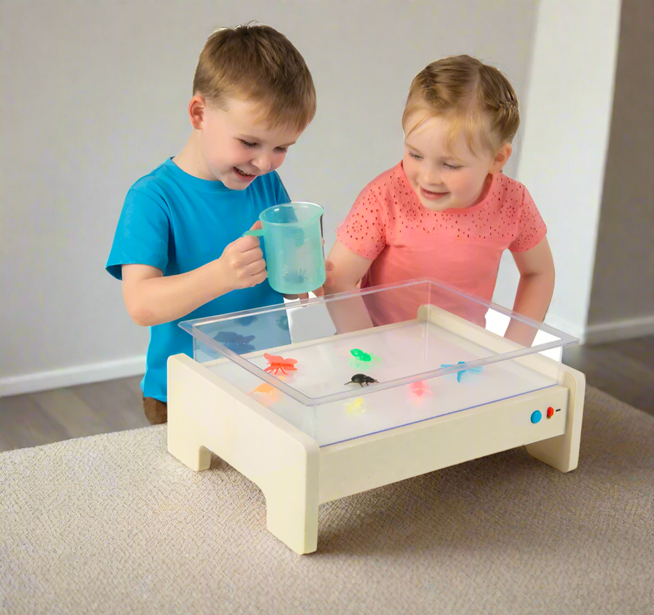 Child playing on Illuminating Activity Table to develop fine motor skills, coordination, and sensory exploration