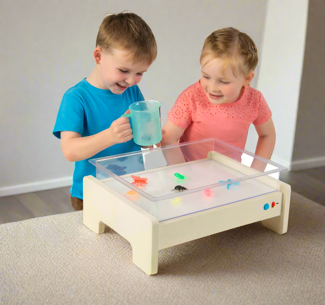 Child playing on Illuminating Activity Table to develop fine motor skills, coordination, and sensory exploration