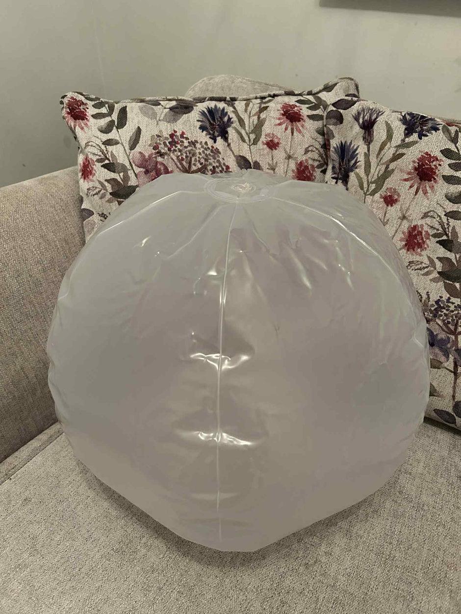 Inflatable 45cm Glow Ball touch activated, this shows the size of the ball sat on a sofa – sensory light toy for kids by The Divergent Den