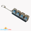 Keyboard fidget toy with four transparent compartments and a metal clip on a white background, branded with 'Divergent Den'.