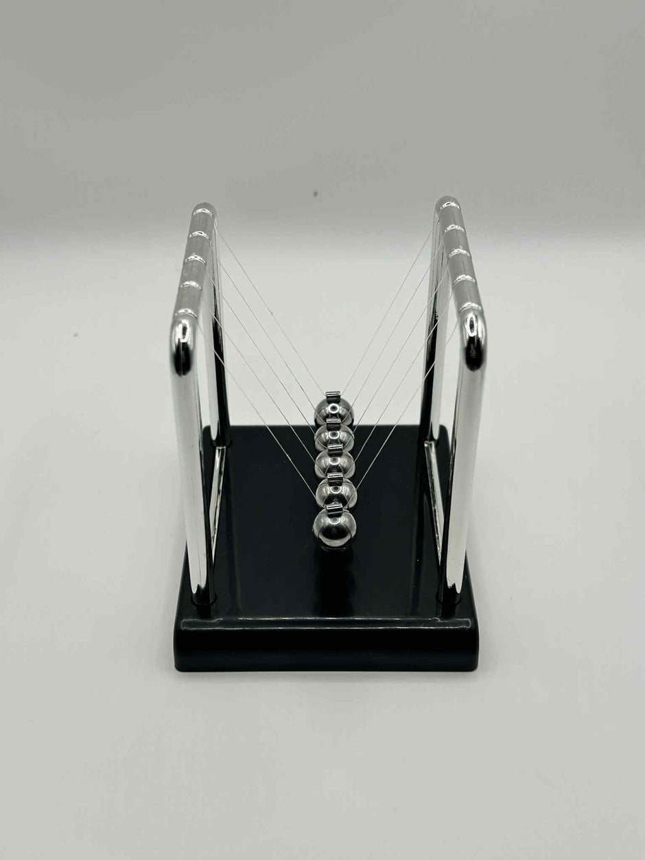 Metal Newton’s Cradle on black base – desktop fidget and stress-relief toy for neurodivergent children | The Divergent Den