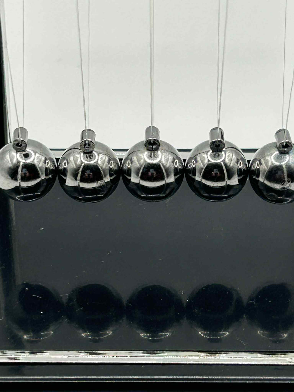 Close-up of metal Newton’s Cradle balls in for calming visual sensory stimulation