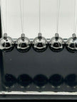 Close-up of metal Newton’s Cradle balls in for calming visual sensory stimulation