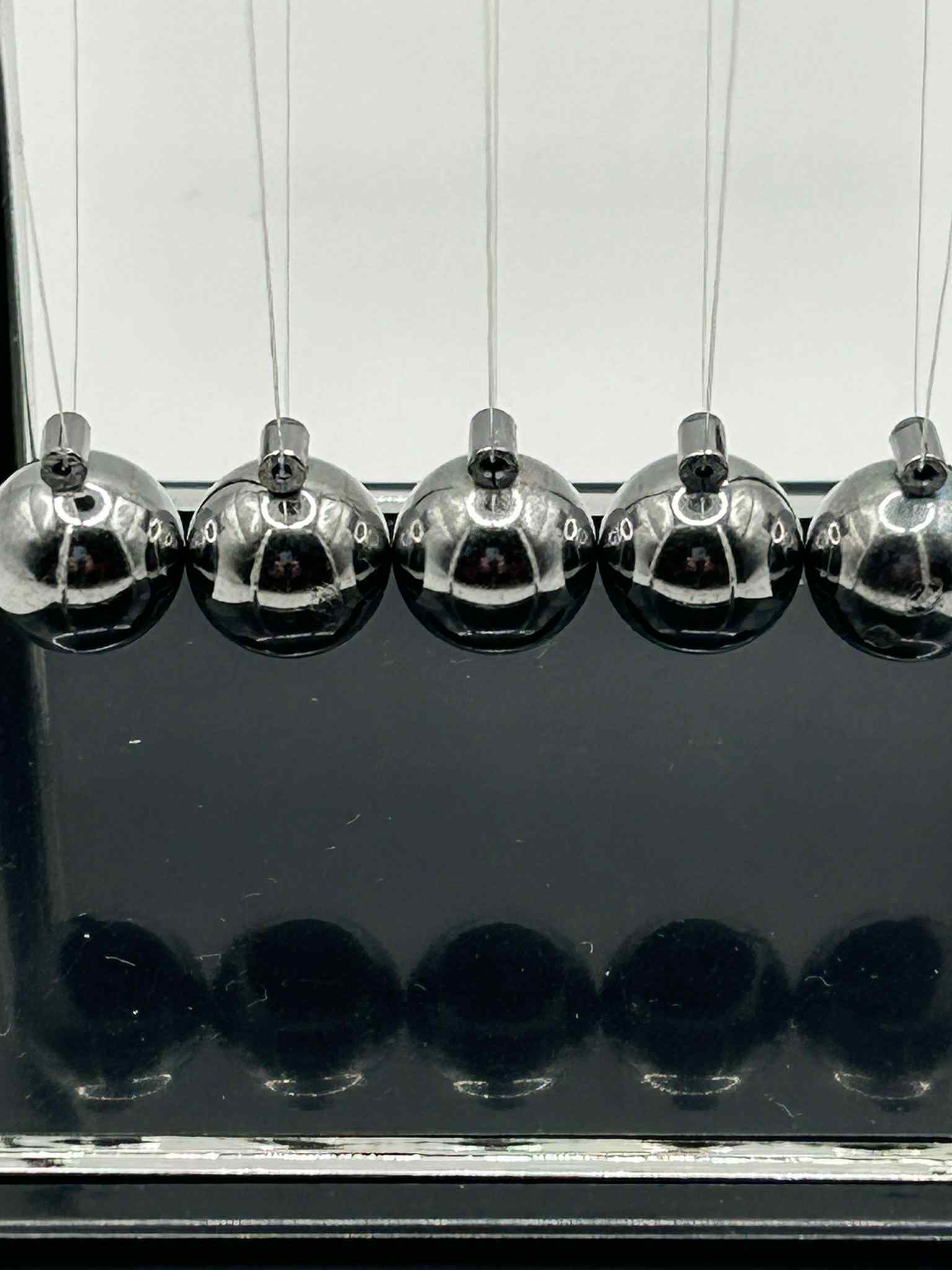 Close-up of metal Newton’s Cradle balls in for calming visual sensory stimulation