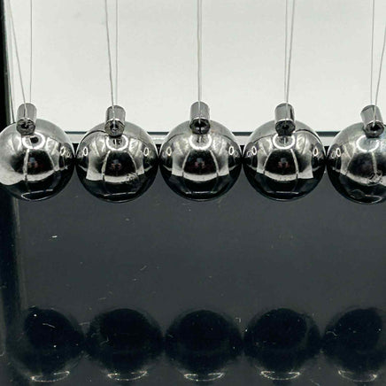 Close-up of metal Newton’s Cradle balls in for calming visual sensory stimulation