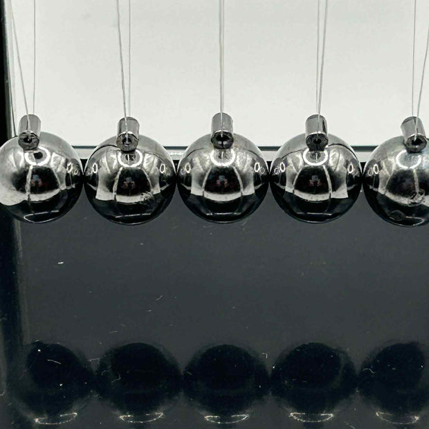 Close-up of metal Newton’s Cradle balls in for calming visual sensory stimulation