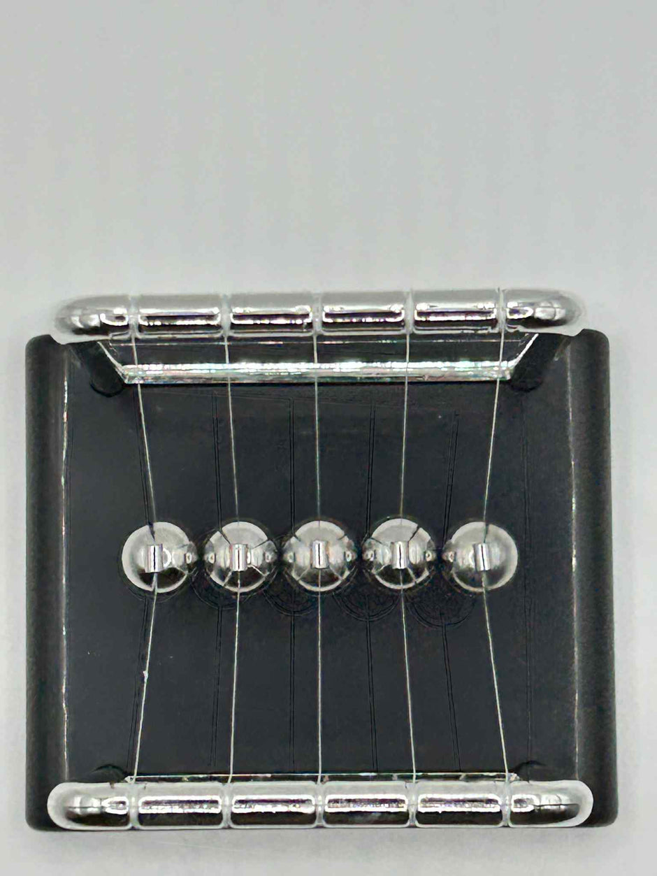 Newton’s Cradle – birdseye view of the classic desk fidget toy for focus and stress relief | The Divergent Den