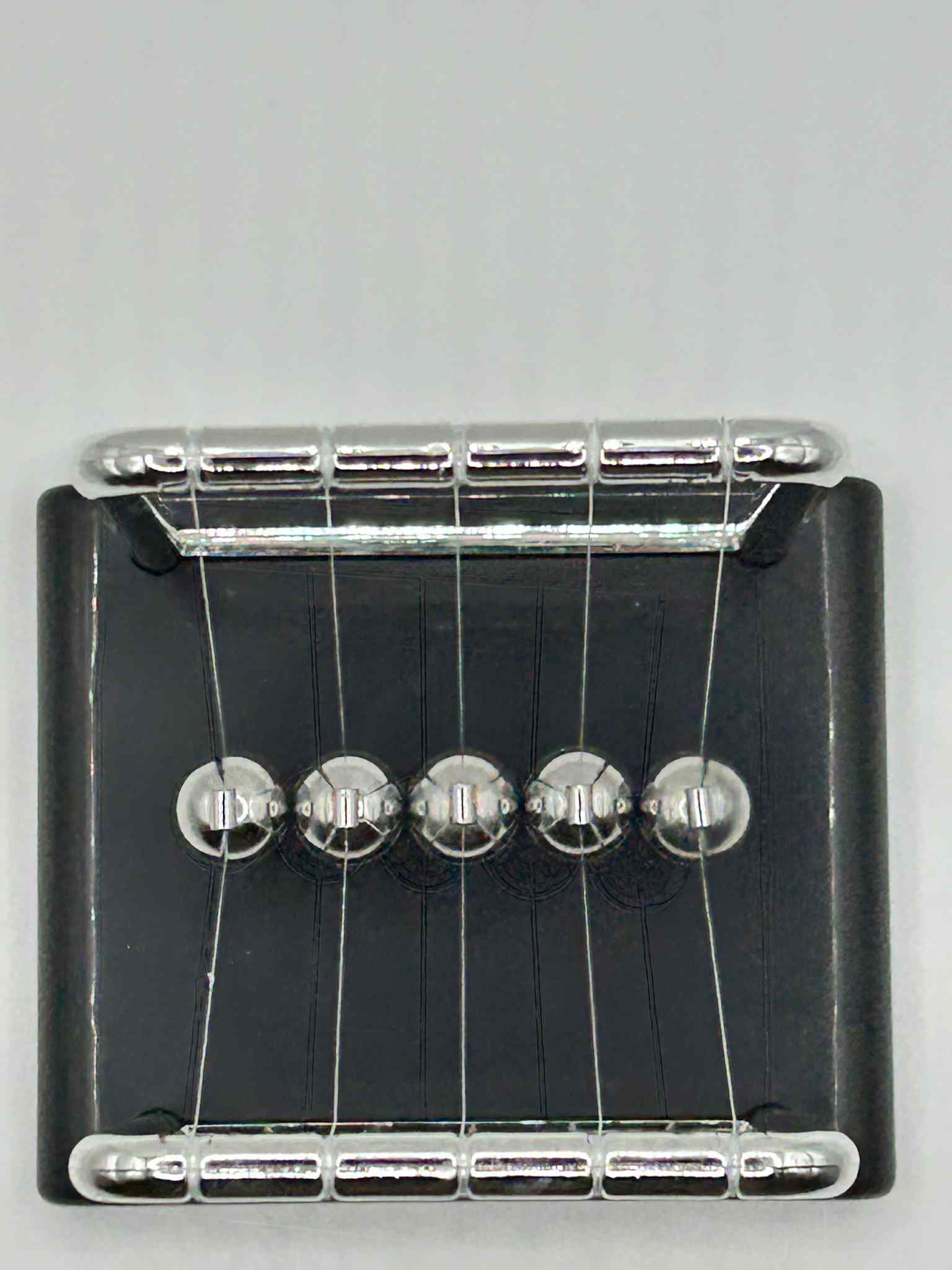 Newton’s Cradle – birdseye view of the classic desk fidget toy for focus and stress relief | The Divergent Den