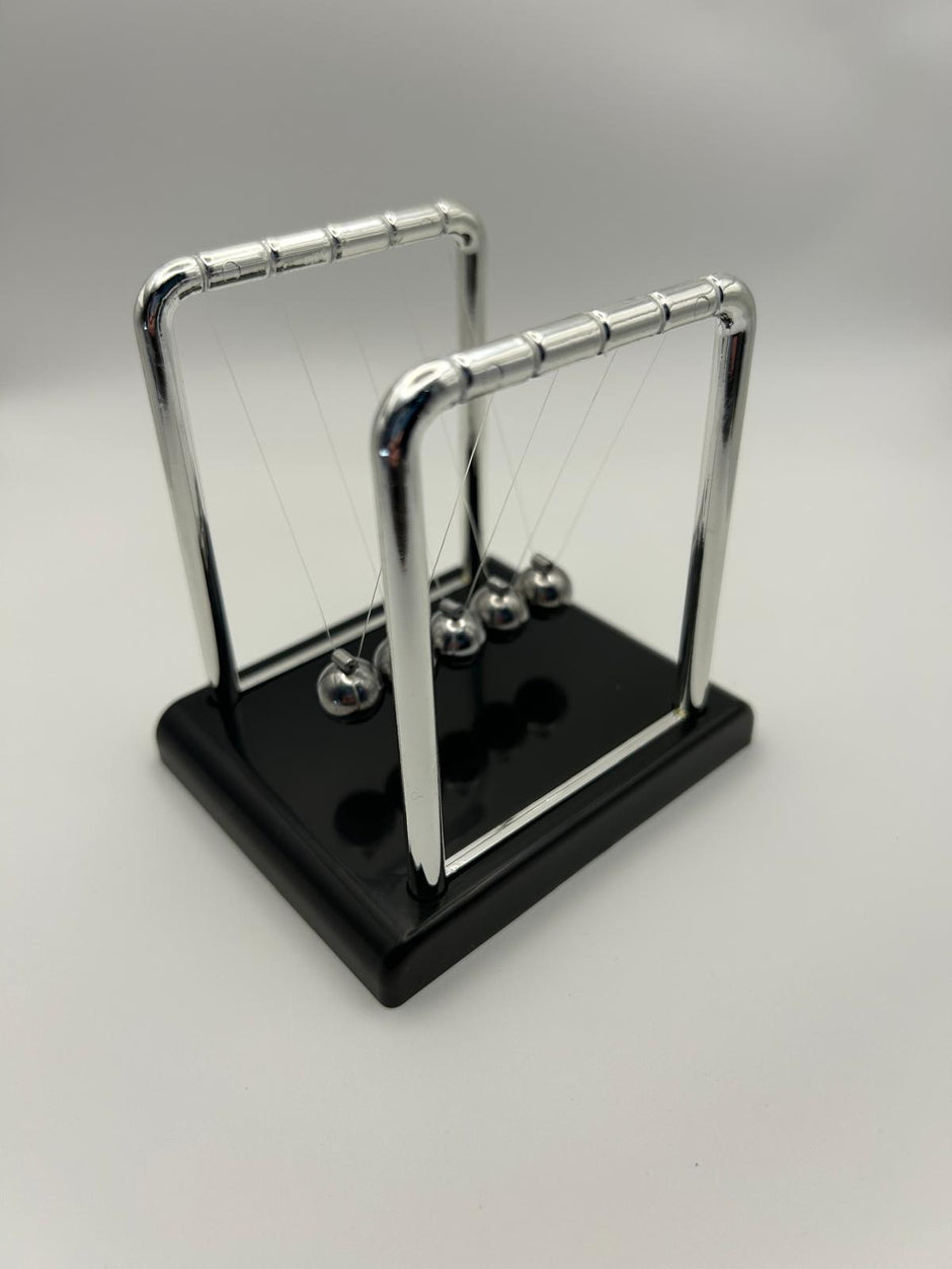 Newton’s Cradle – side angle of the classic desk fidget toy for focus and stress relief | The Divergent Den