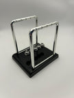 Newton’s Cradle – side angle of the classic desk fidget toy for focus and stress relief | The Divergent Den