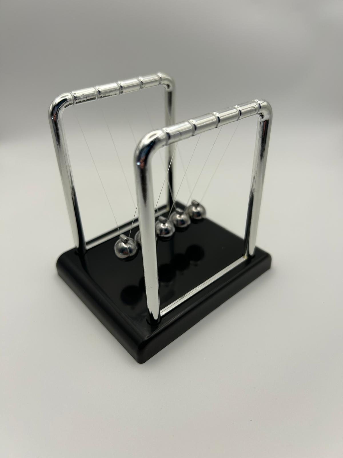 Newton’s Cradle – side angle of the classic desk fidget toy for focus and stress relief | The Divergent Den