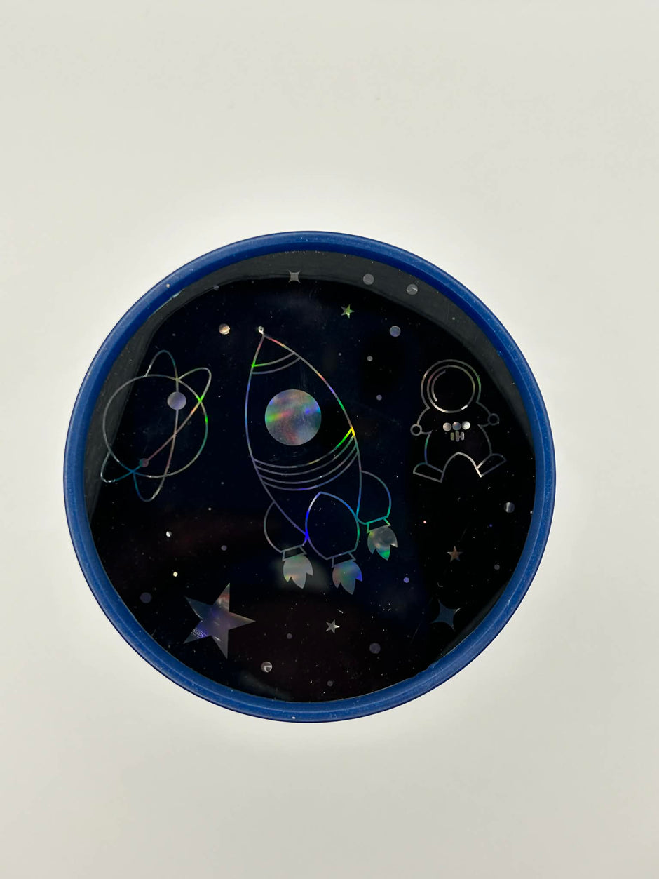 Sensory night light projector space at a top view with space-themed design featuring a rocket and astronaut on a dark background.