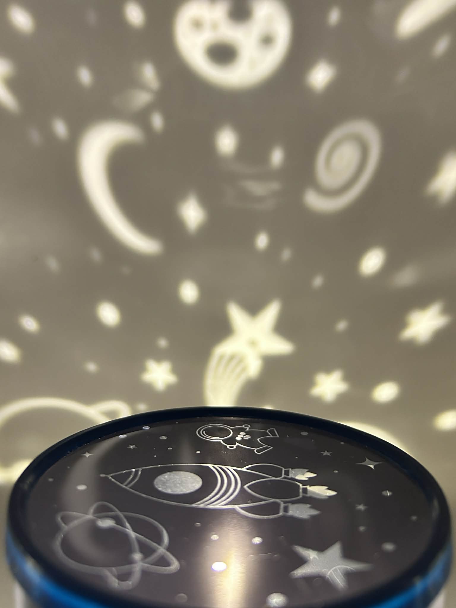Sensory night light projector | Cosmic design projector with star and moon patterns on a dark background