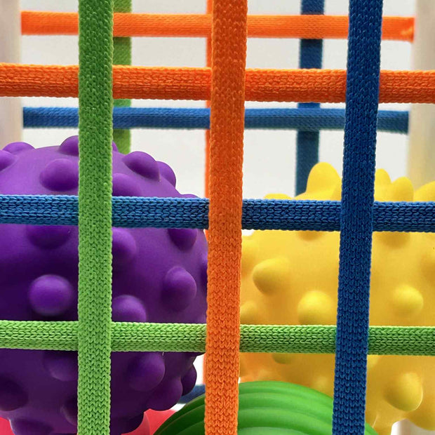 Close-up of Sensory Seekers Sorting Box showing 4 textured balls and soft ribbon openings for sensory play