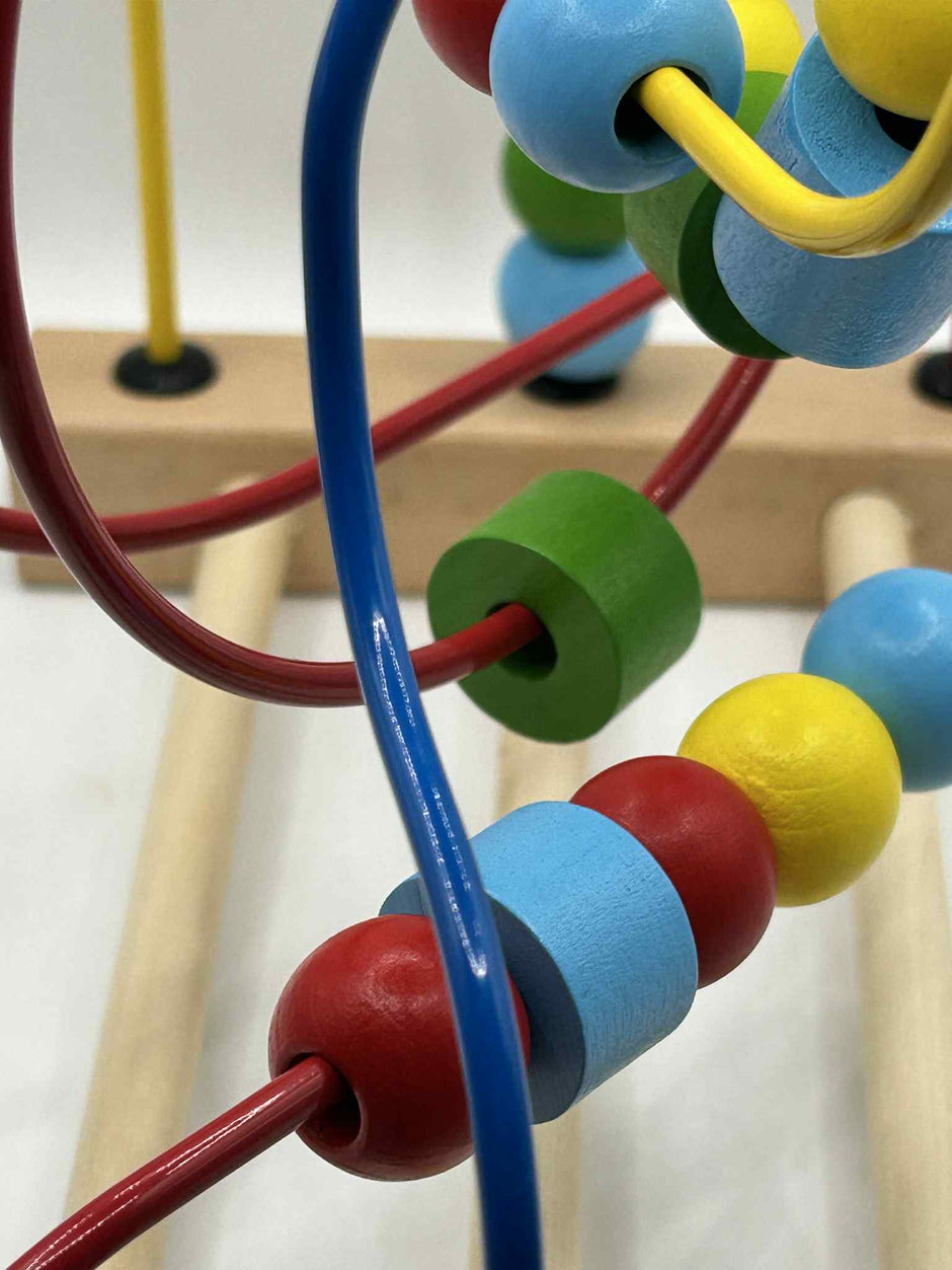 Close-up of Wooden Bead Maze showing the tracks the beads run alongside showing colourful wooden beads on wire tracks for tactile play