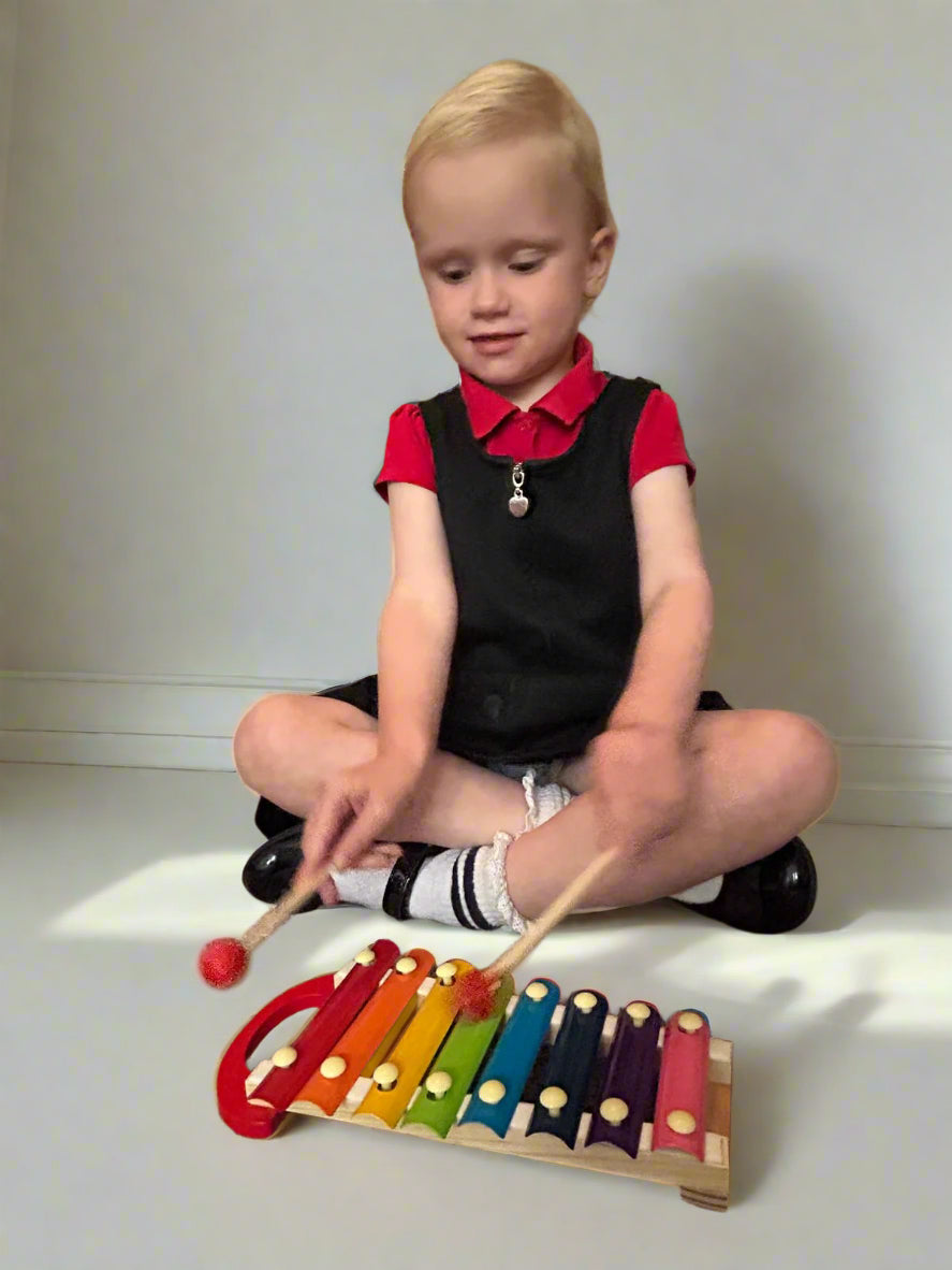 Toddler playing Wooden Xylophone to improve coordination, focus, and sensory engagement